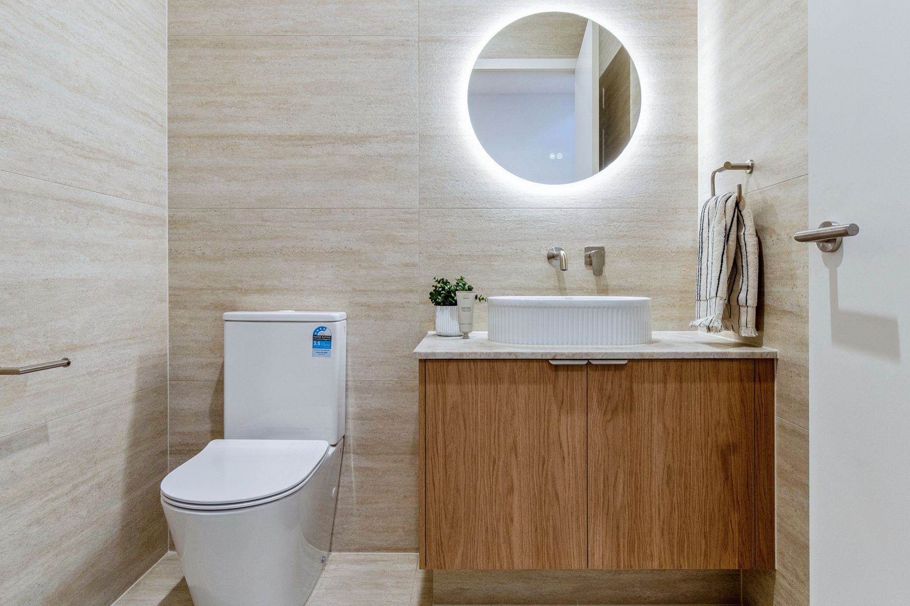 Mt Eliza townhouse powder room with backlit round mirror