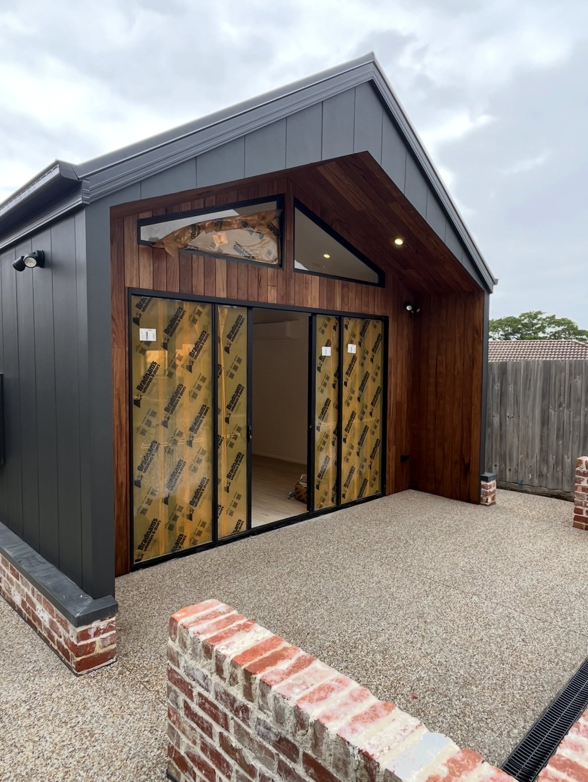 Somerville new build exterior with timber entry and black-framed glazing